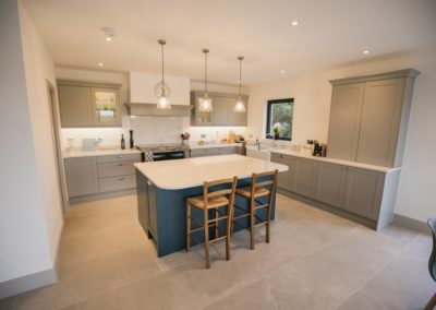 renovated kitchen with blue island and grey cupboards